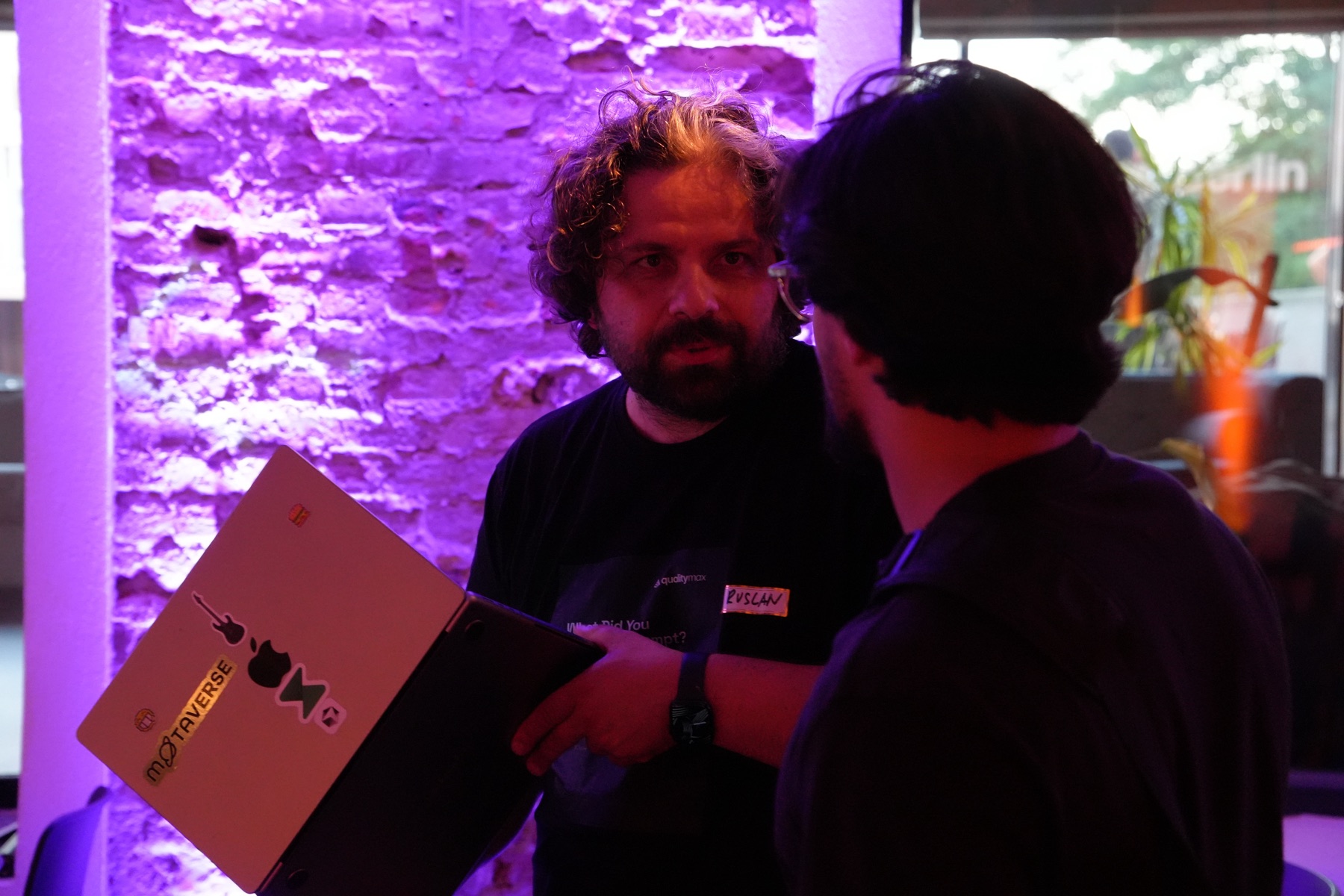 Ruslan Strazhnyk speaking with an attendee after presenting QualityMax at Berlin SaaS Night